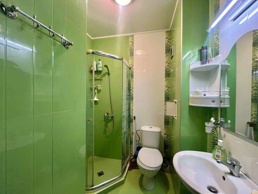 Cozy Green Bathroom in Odissey Studio Green bathroom with shower, toilet, and sink in Odissey studio Nessebar.