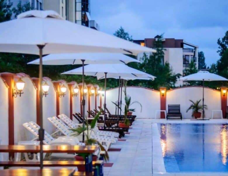 Poolside relaxation area with sun loungers and umbrellas at Tarsis - Club & Spa.