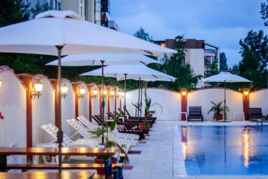 Modern pool area with sun loungers and umbrellas at Tarsis – Club & Spa. Poolside relaxation area with sun loungers and umbrellas at Tarsis - Club & Spa.