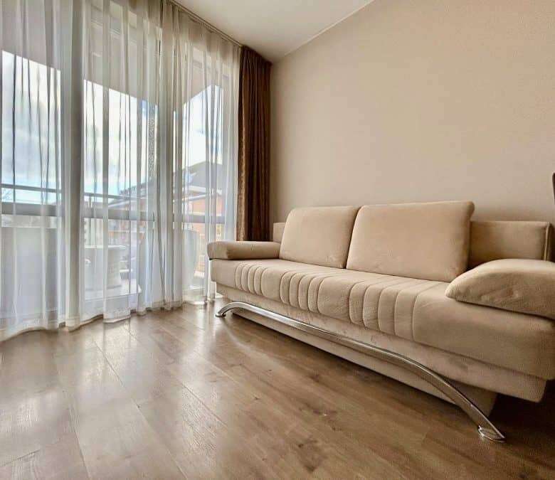 Bright living room with large windows and a beige sofa in Tarsis, Sunny Beach.