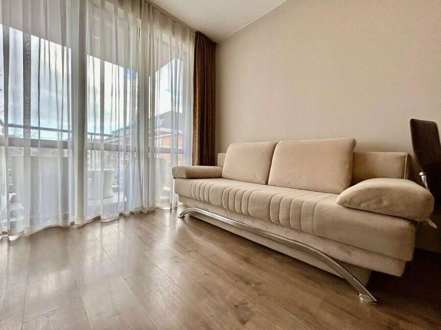 Cozy 1-Bed Apartment in Tarsis – Sunny Beach Bright living room with large windows and a beige sofa in Tarsis, Sunny Beach.