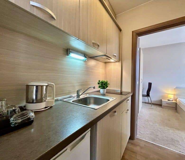 Bright, compact kitchen with sink, countertop, and essential appliances.