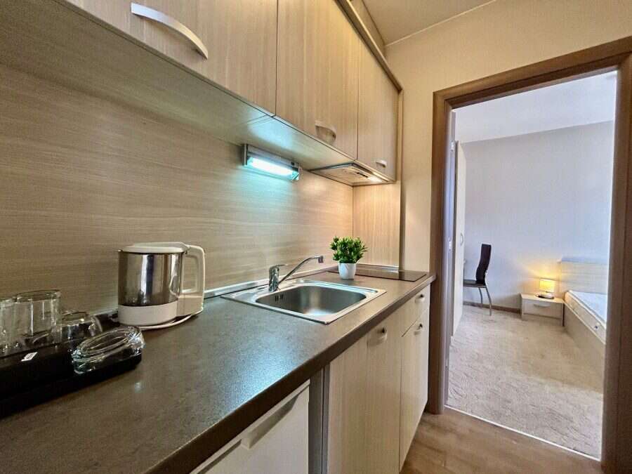 Modern kitchen in Tarsis – Club & Spa apartment, Sunny Beach, Bulgaria. Bright, compact kitchen with sink, countertop, and essential appliances.