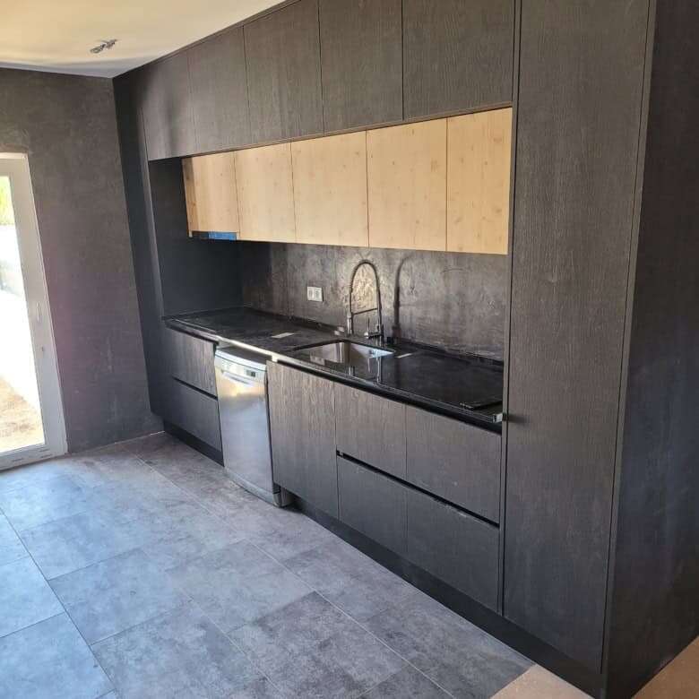Stylish black and wood kitchen in a luxurious Setubal villa. Perfect for contemporary living and ent.
