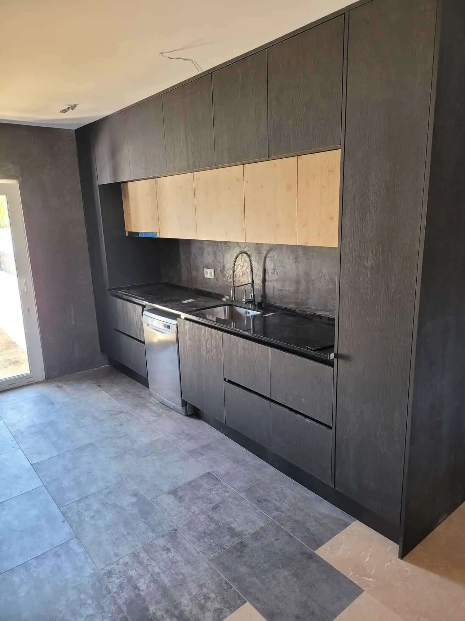 Stylish black and wood kitchen in a luxurious Setubal villa. Perfect for contemporary living and ent.