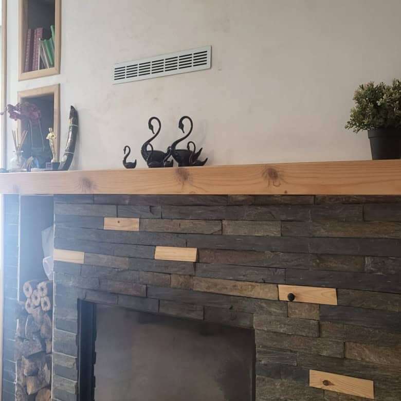 Modern fireplace with a sleek black finish and stylish wooden accents in a contemporary living space.