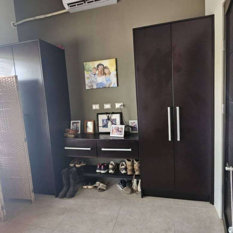 Spacious bedroom featuring a sleek wardrobe, air conditioner, and decorative wall art.