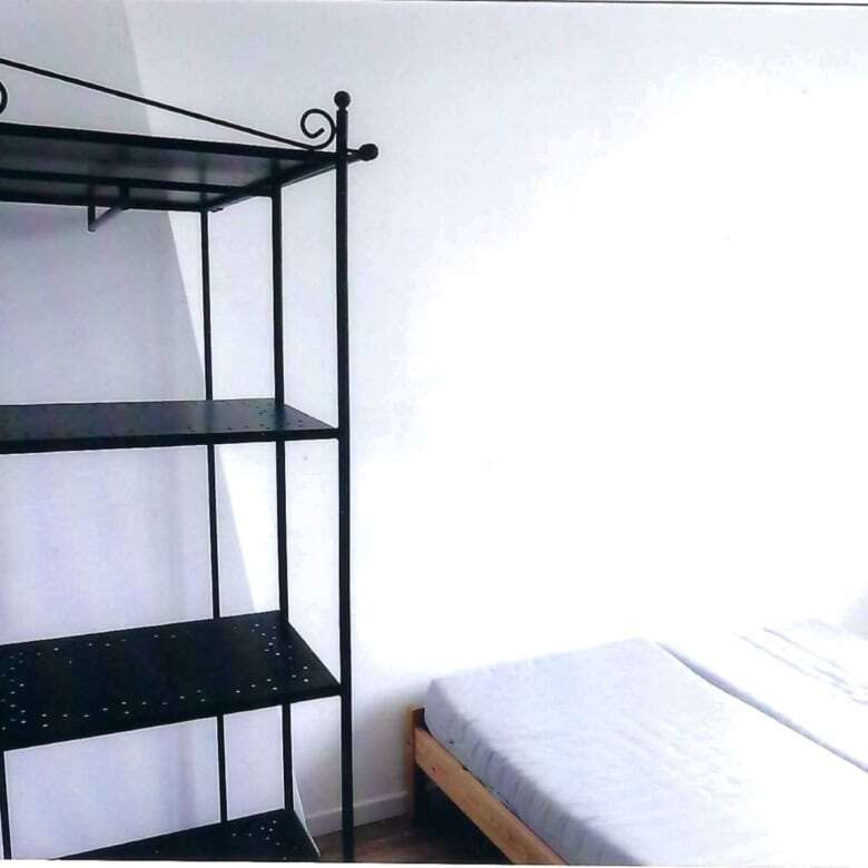 Interior view of a bedroom in a seaside house with a metal shelf and a bed in Mers Les Bains.