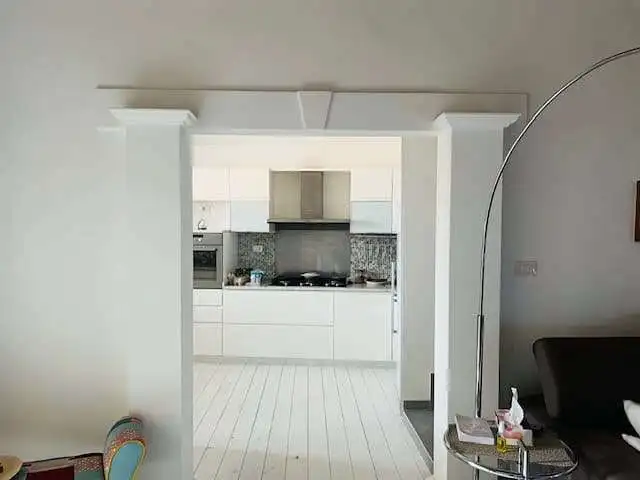 Modern white kitchen with sleek cabinets and stainless steel appliances in Chiaramonti, Sardinia.