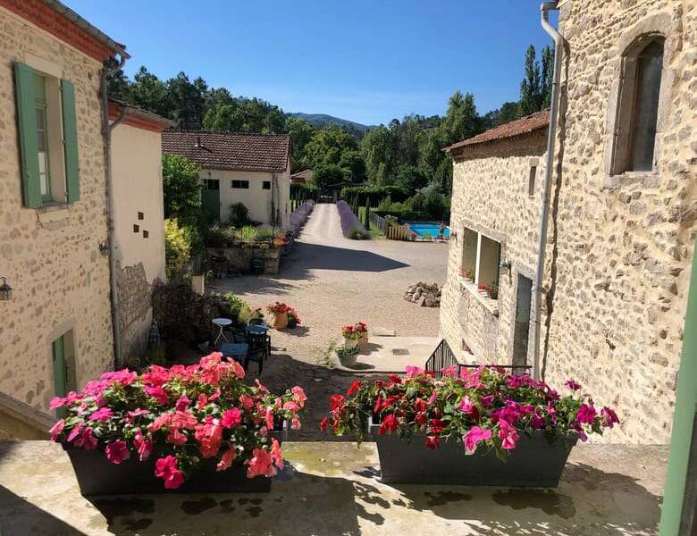Beautiful country estate with stone buildings and vibrant flowers in Branoux les Taillades.
