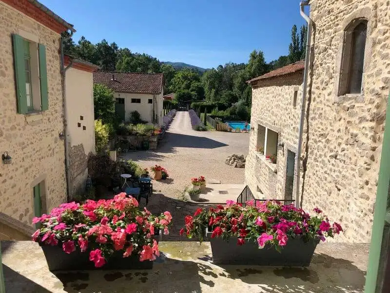 Beautiful country estate with stone buildings and vibrant flowers in Branoux les Taillades.