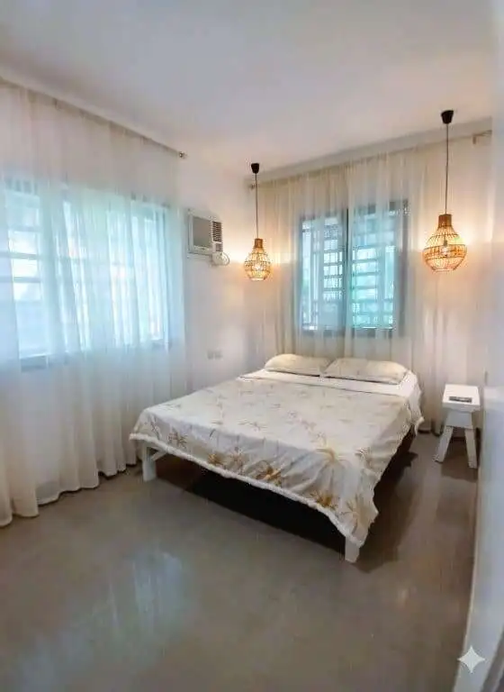 Interior view of a cozy 3-bedroom house in Siargao Island with bright windows and modern decor.
