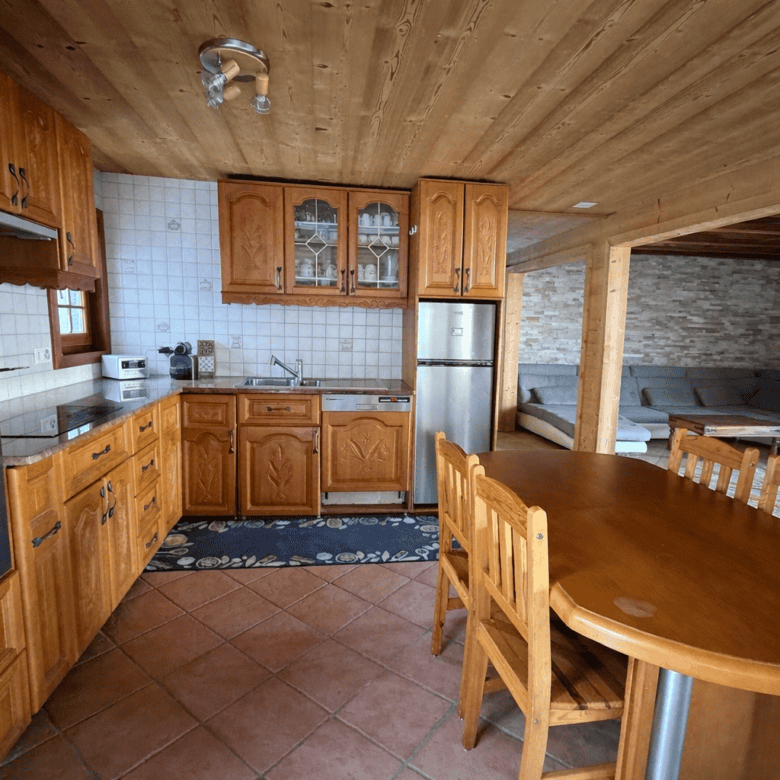 Cozy Swiss chalet kitchen with wooden cabinets and mountain views, ideal for holiday or rental stays.