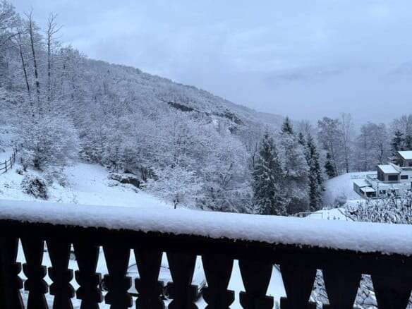 Charming Swiss chalet overlooking snow-covered mountains and forest, perfect for holiday stays or re.