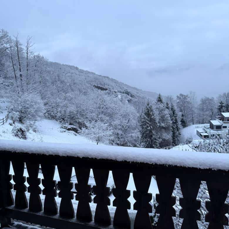 Charming Swiss chalet overlooking snow-covered mountains and forest, perfect for holiday stays or re.