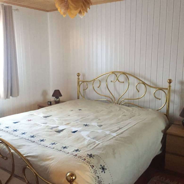 Cozy bedroom with a gold ornate bed frame and mountain views, perfect for holiday or rental stays.