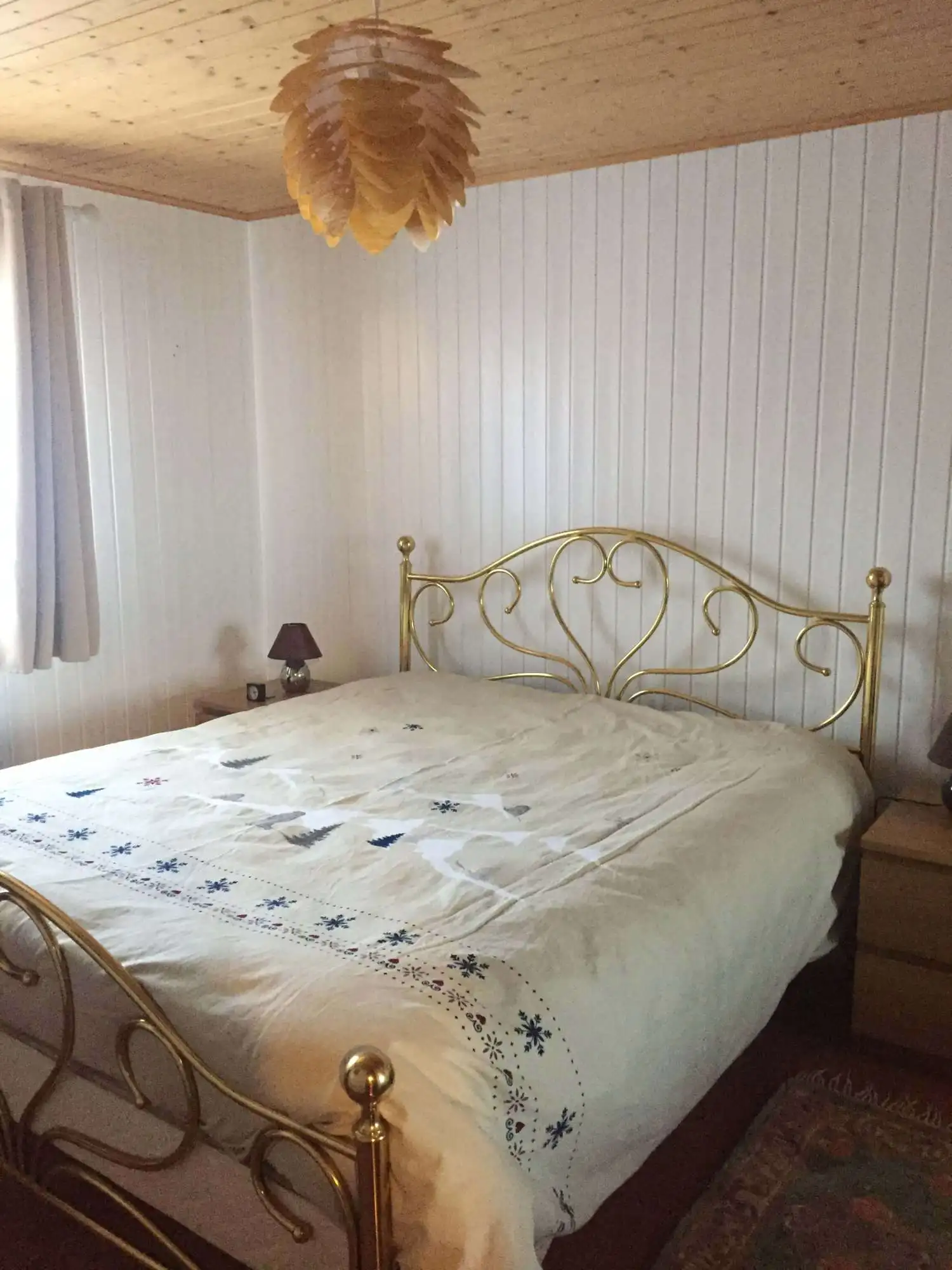Cozy bedroom with a gold ornate bed frame and mountain views, perfect for holiday or rental stays.