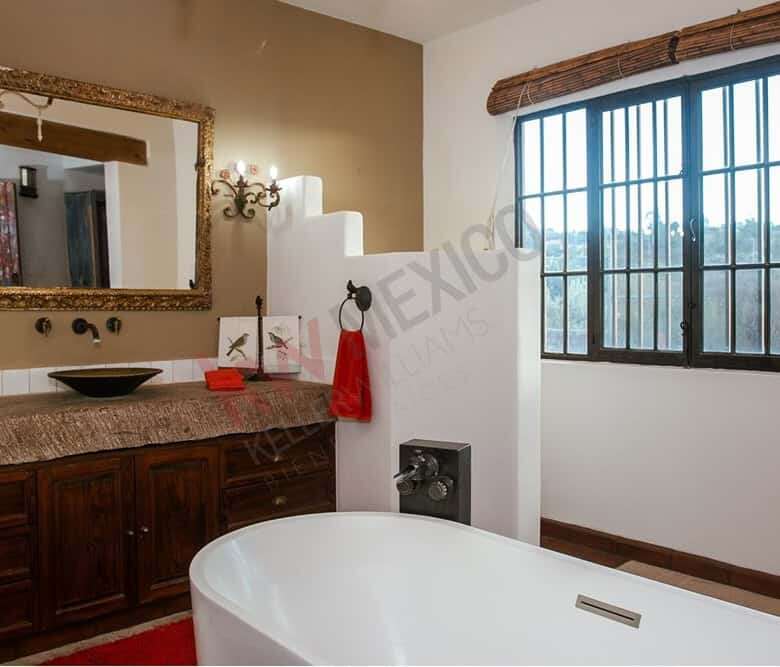 Spacious bathroom featuring a large window with scenic views, a stylish vanity, and a modern bathtub.