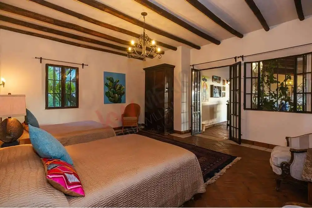Elegant Colonial Bedroom with Allende Dam Views Beautiful colonial bedroom with rustic wooden beams and large windows overlooking Allende Dam.