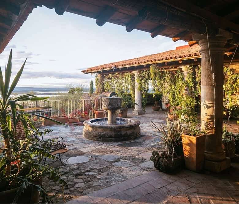 Colonial estate terrace with dam views and lush greenery.