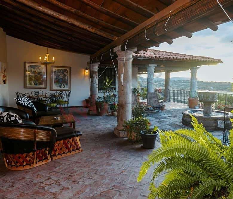 Terrace of a colonial estate overlooking Allende Dam in San Miguel de Allende, featuring rustic wood.