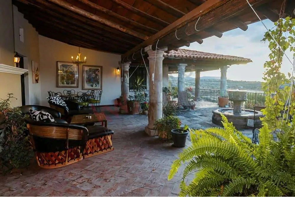 Elegant colonial estate terrace with dam views in San Miguel de Allende Terrace of a colonial estate overlooking Allende Dam in San Miguel de Allende, featuring rustic wood.