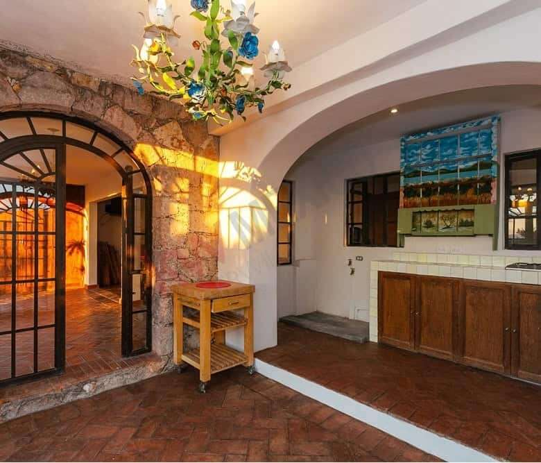 Charming colonial estate interior featuring stone walls, arched doorways, and vibrant decor in San M.