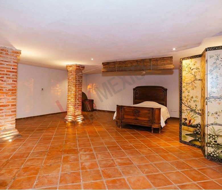 Spacious bedroom with rustic brick columns and dam views in San Miguel de Allende.