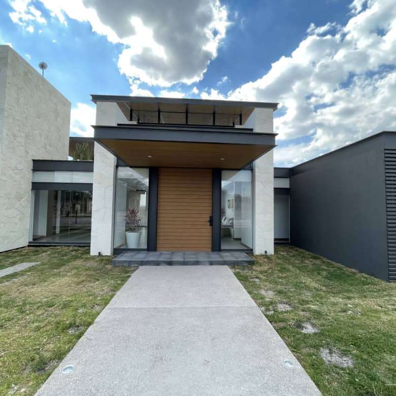 Elegant villa entrance with contemporary design and lush lawn in San Miguel de Allende, Mexico.