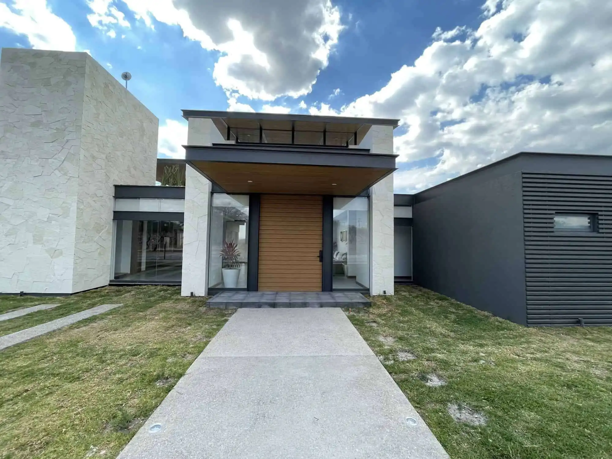 Elegant villa entrance with contemporary design and lush lawn in San Miguel de Allende, Mexico.