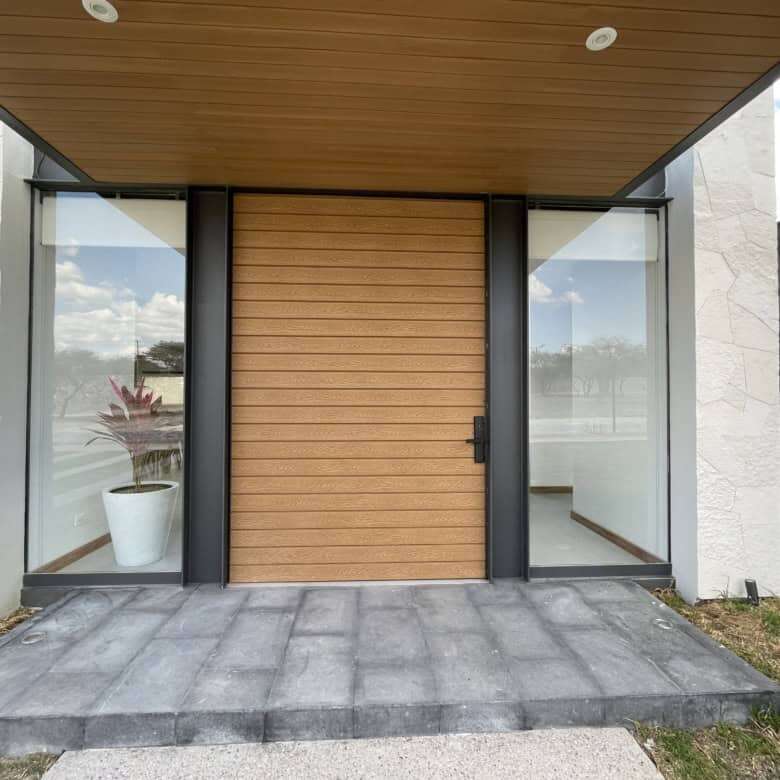 Modern home entrance with wooden door and glass panels in San Miguel de Allende.