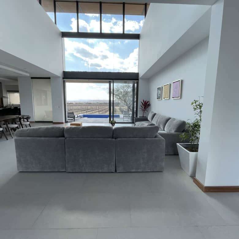 Spacious contemporary living area with floor-to-ceiling windows and elegant furnishings.