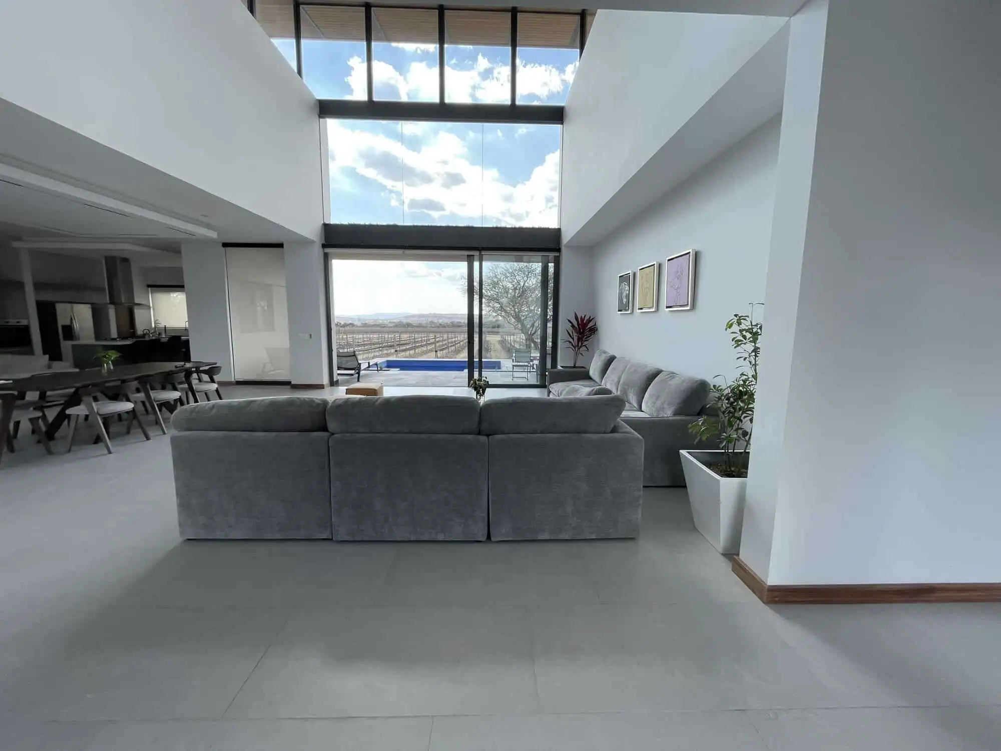 Spacious contemporary living area with floor-to-ceiling windows and elegant furnishings.