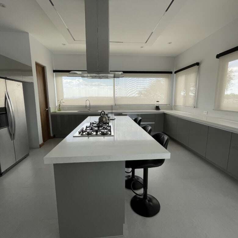 Modern kitchen with large island and stainless steel appliances.