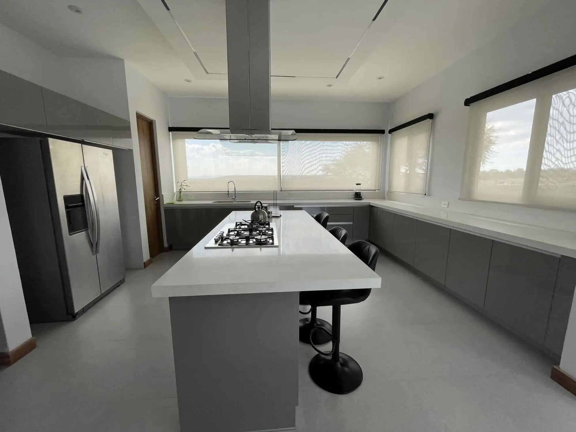 Modern kitchen with large island and stainless steel appliances.