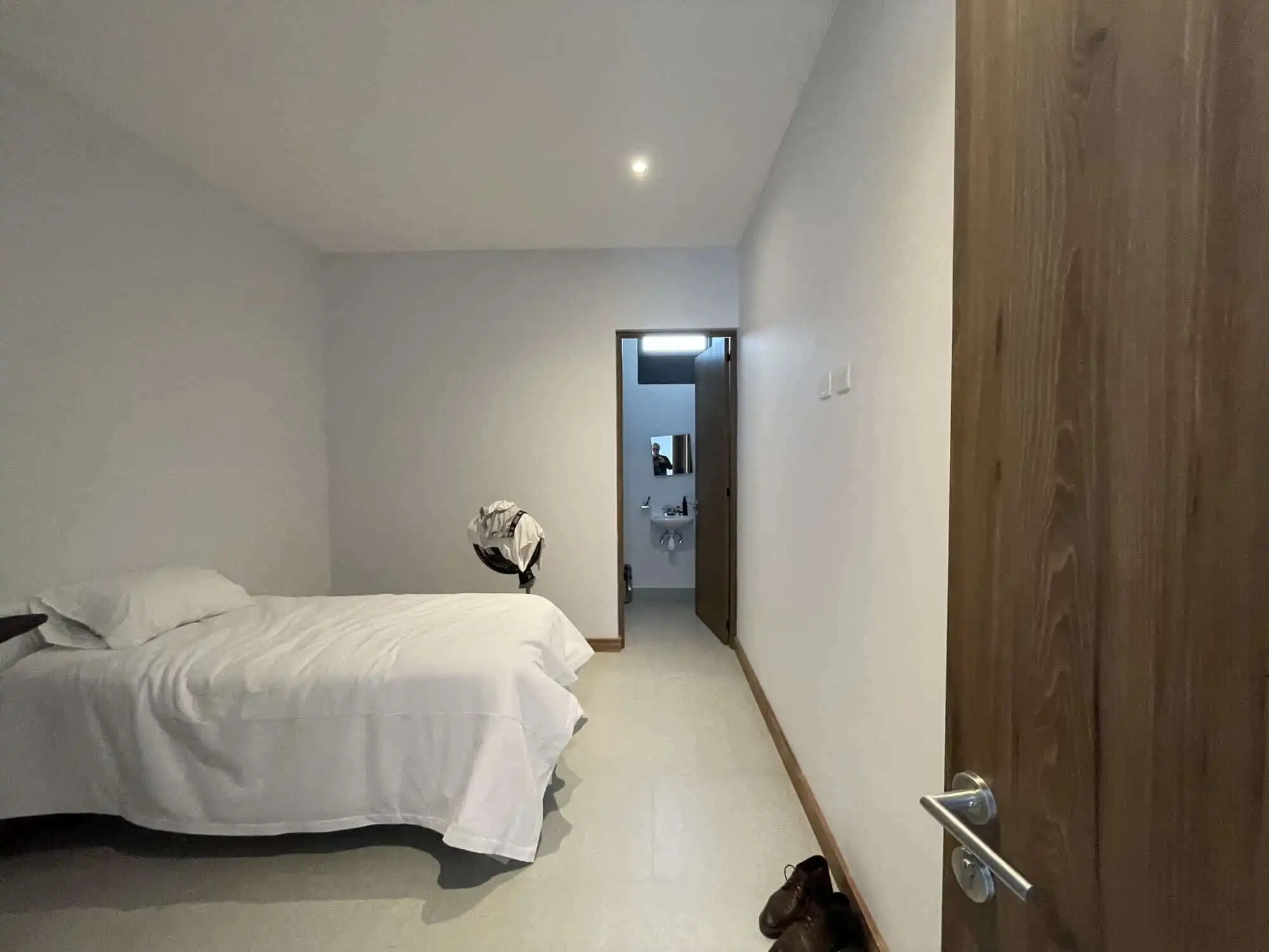 Spacious bedroom featuring a minimalist style with white bedding and simple decor in a high-end vine.