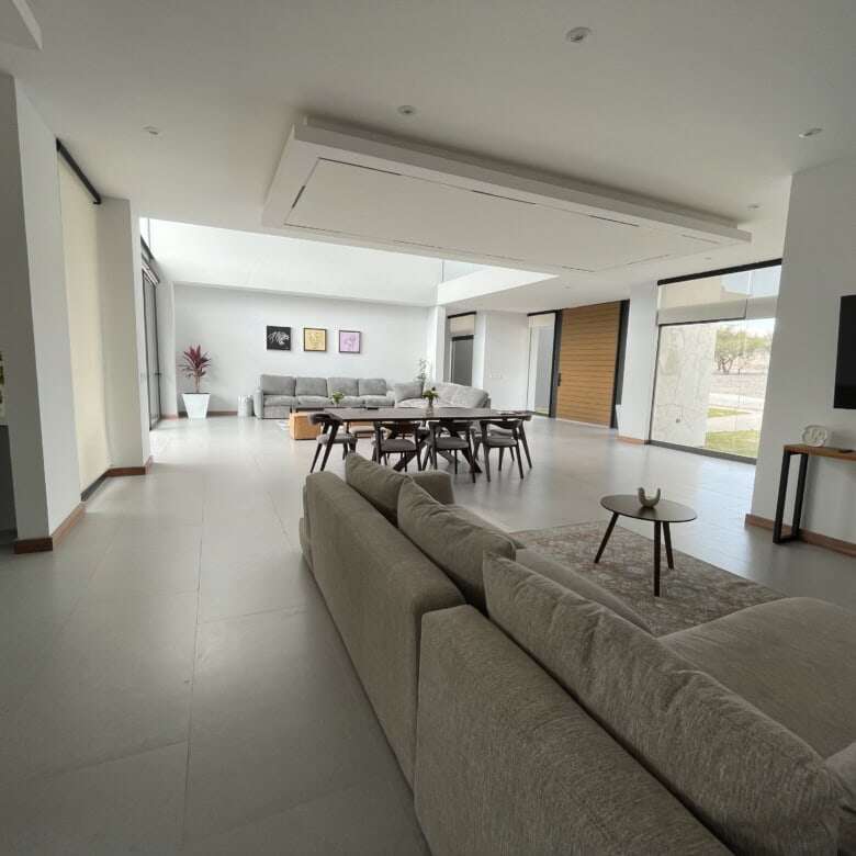 Spacious modern living room with large windows, stylish furniture, and elegant decor in a luxury vin.