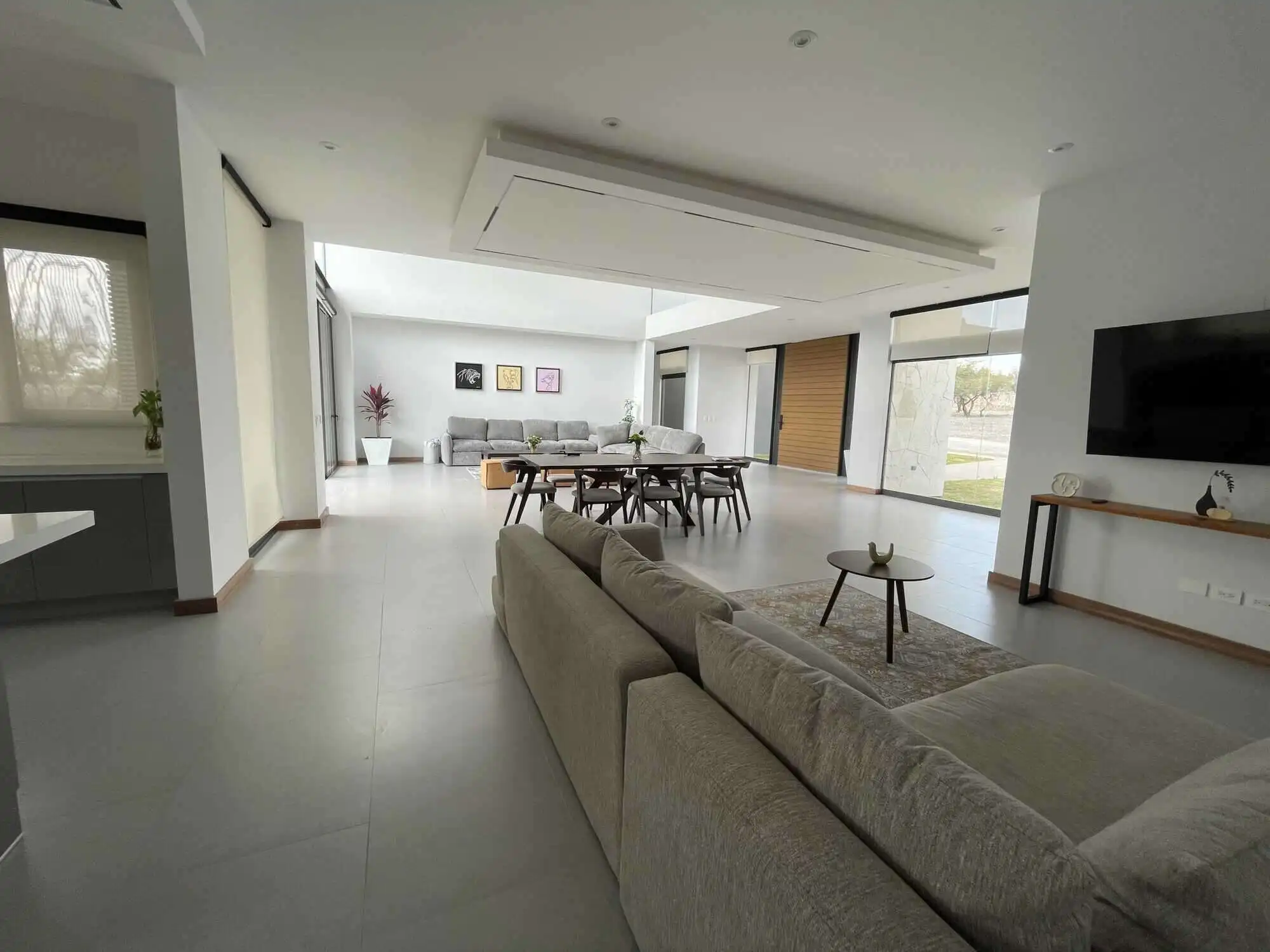 Spacious modern living room with large windows, stylish furniture, and elegant decor in a luxury vin.
