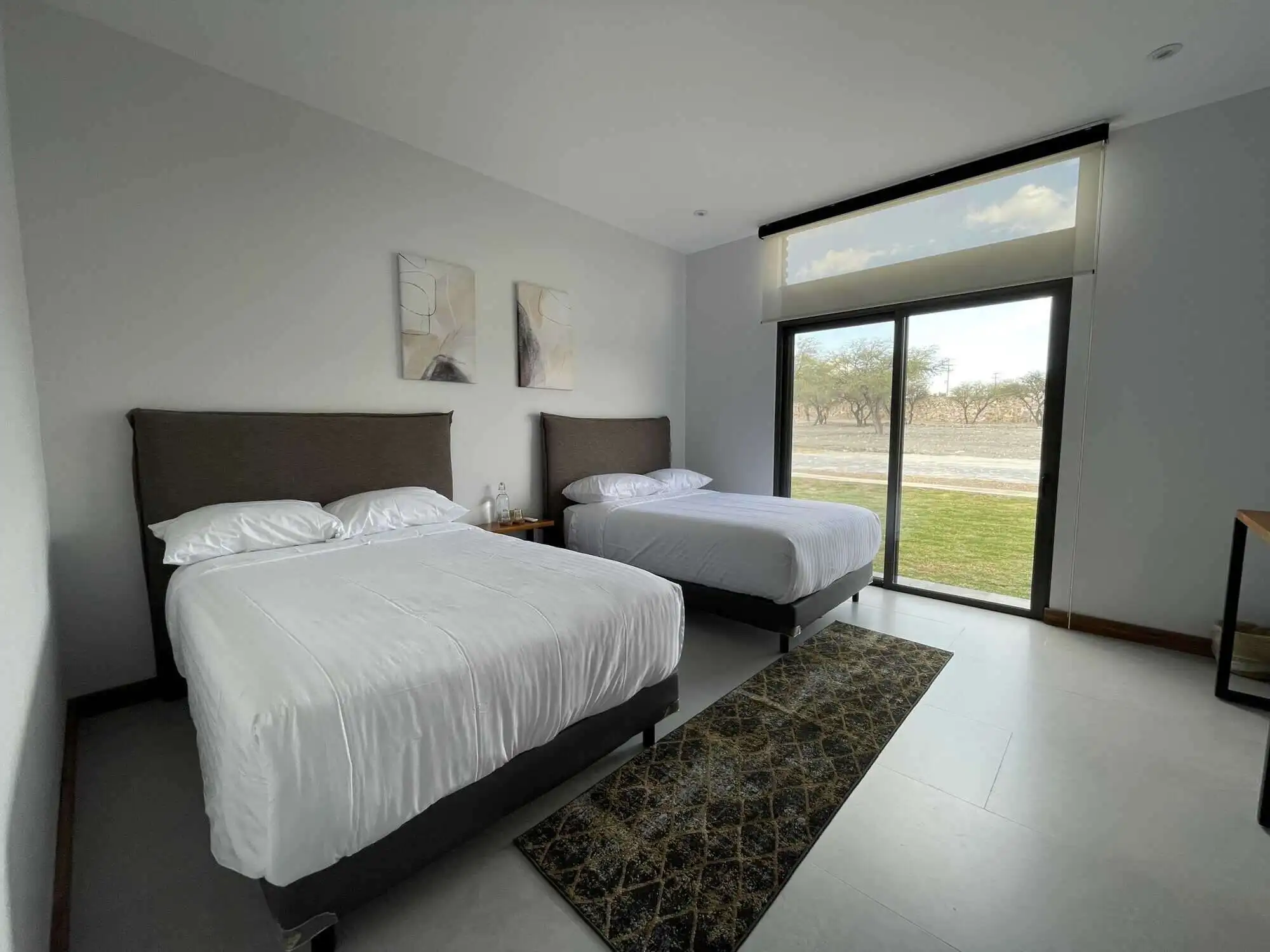 Elegant bedroom with two comfortable beds and modern decor in San Miguel de Allende.