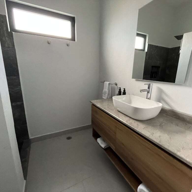 Contemporary bathroom featuring a stylish vessel sink, wooden vanity, and natural light.