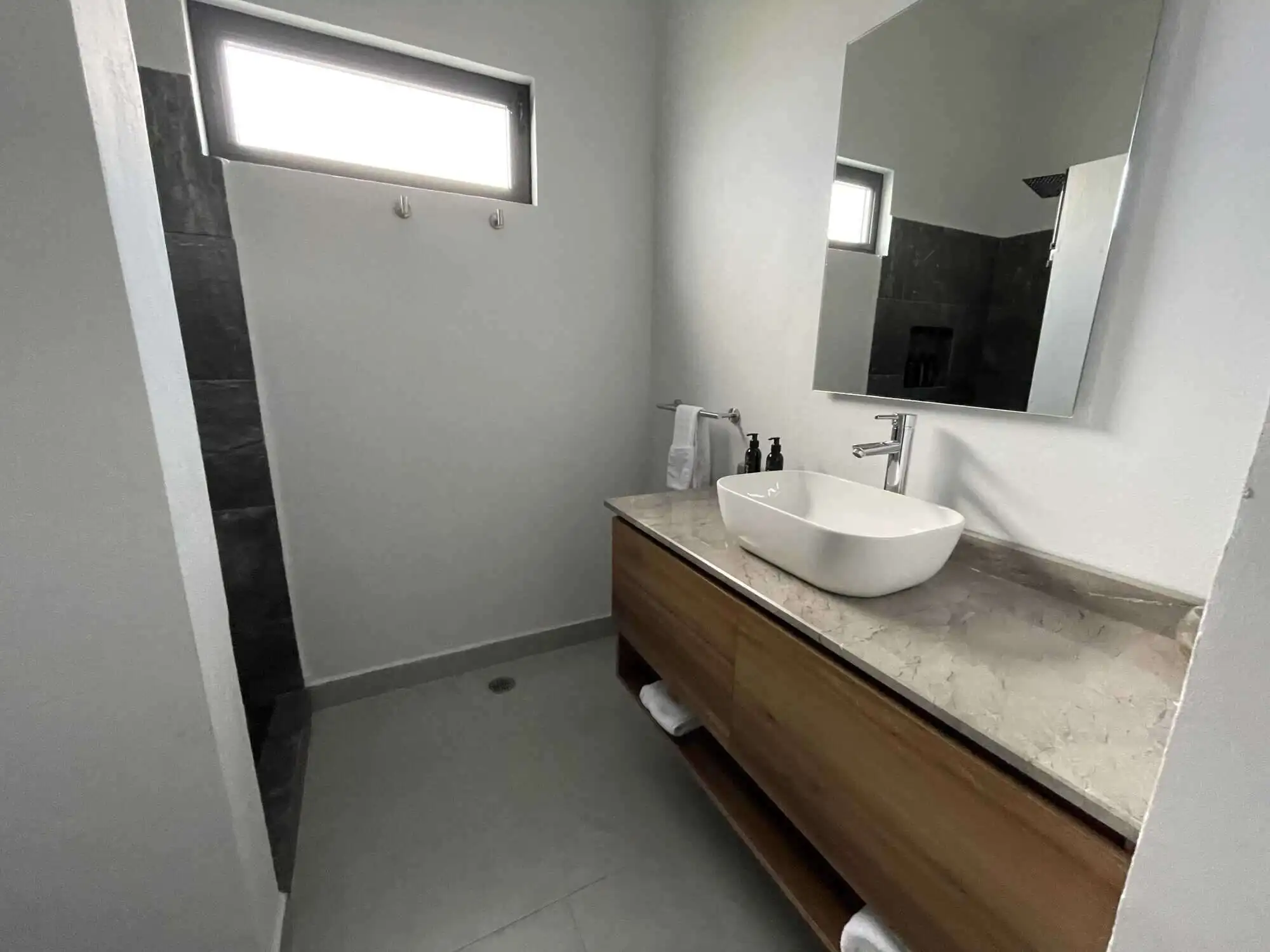 Contemporary bathroom featuring a stylish vessel sink, wooden vanity, and natural light.