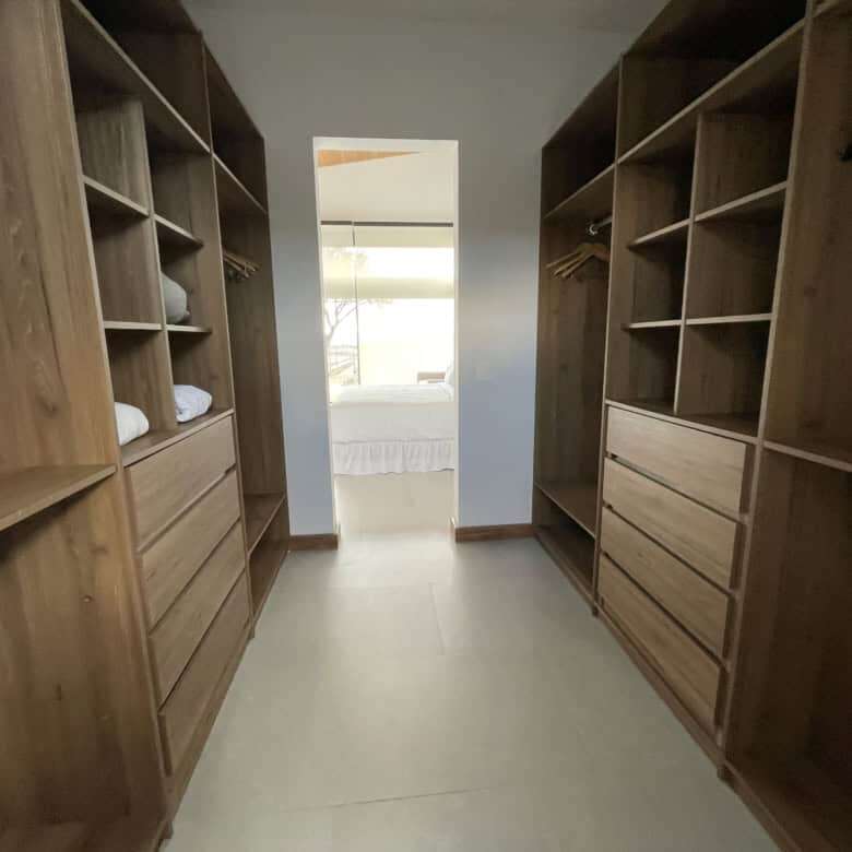 Elegant walk-in closet with wooden shelves and drawers.
