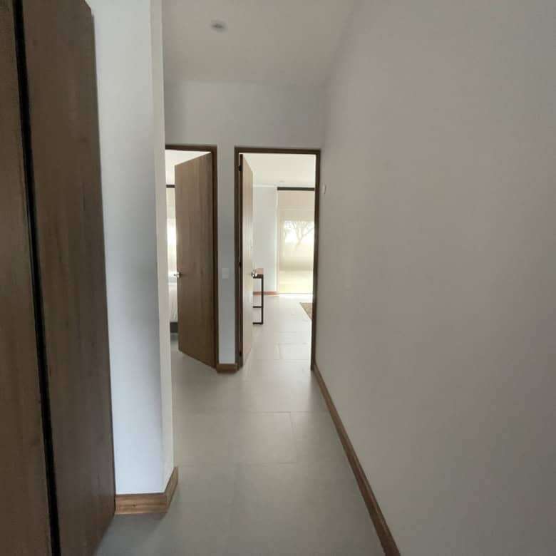 Spacious hallway with wooden accents leading to elegant rooms in a high-end property.