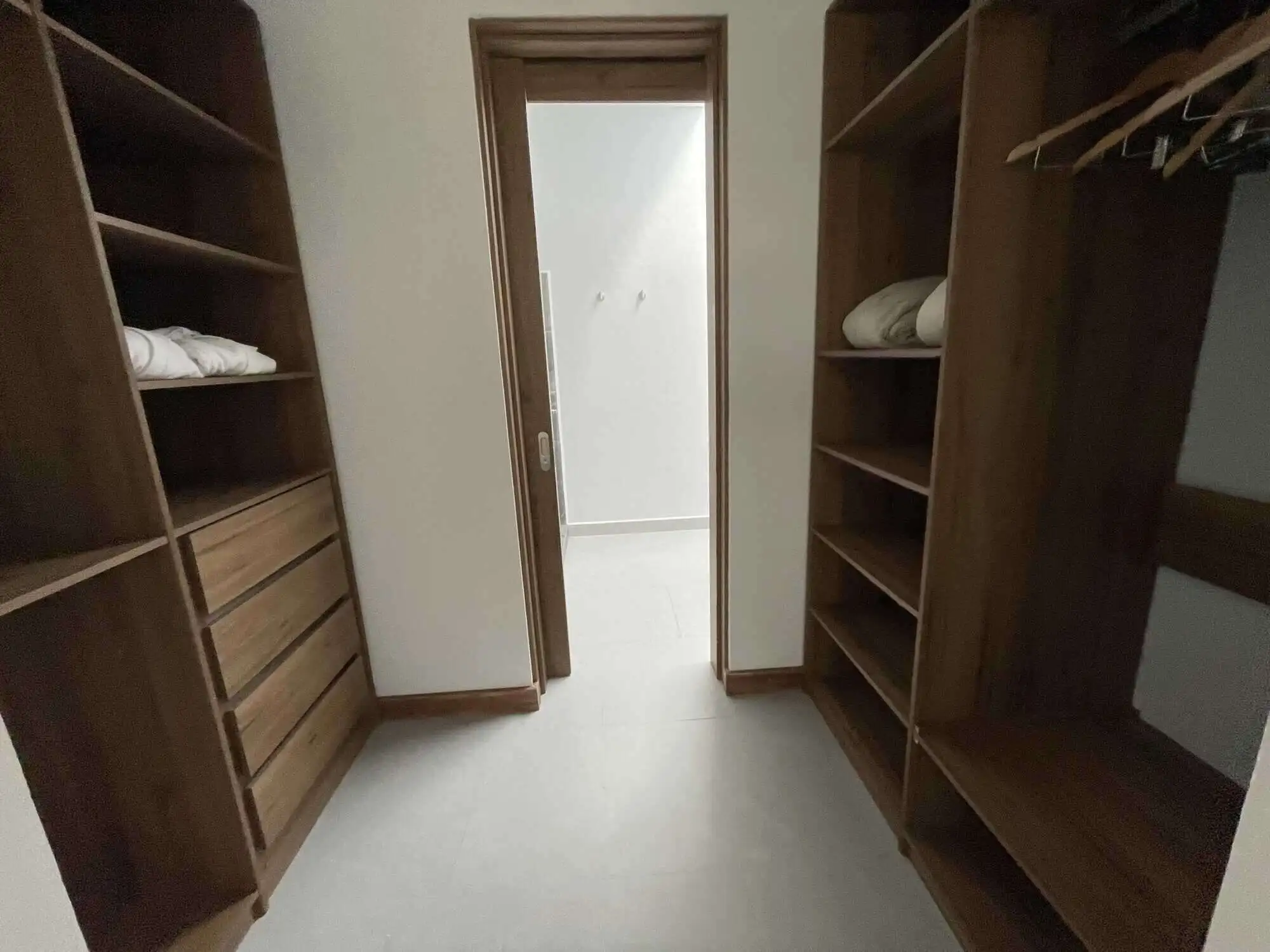 Elegant walk-in closet with wooden shelves and hanging space.