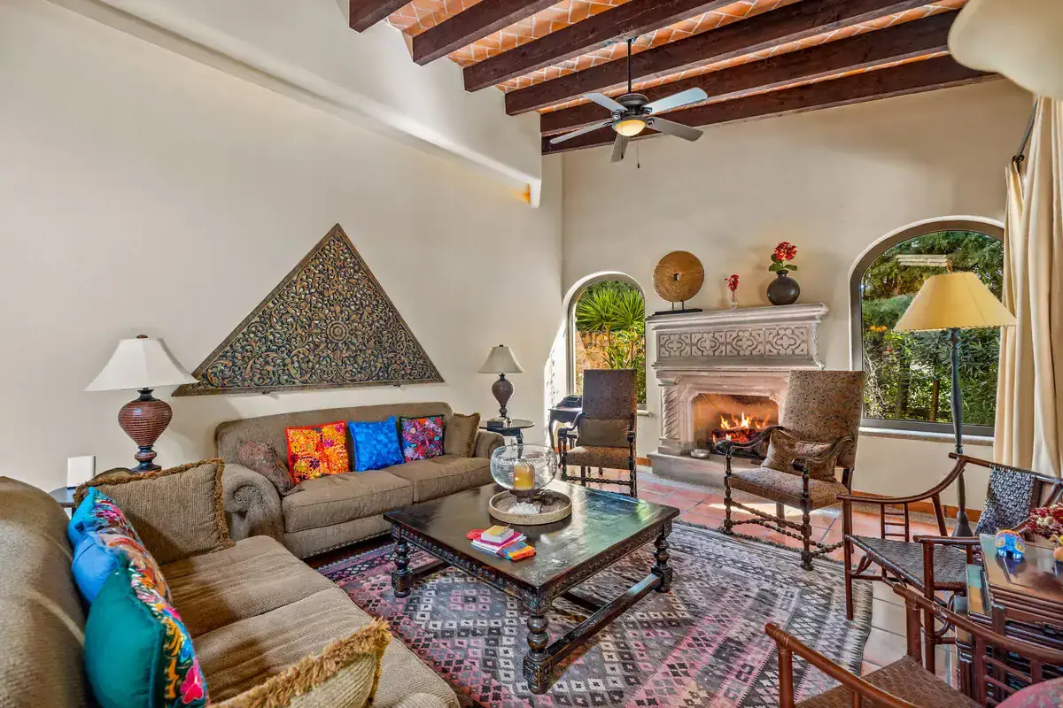 Cozy Living Room with Fireplace in Rancho Los Labradores Inviting living room with fireplace, colorful cushions, and wooden ceiling beams in Rancho Los Labra.