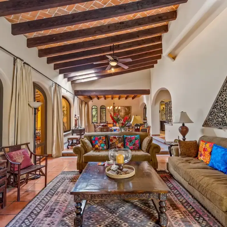 Beautiful living room with high wooden beams and large windows overlooking the lake.