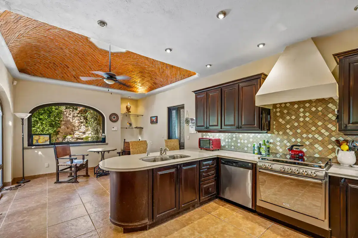 Modern Rancho Los Labradores Kitchen with Brick Ceiling Spacious kitchen in Rancho Los Labradores featuring dark wood cabinets, a brick ceiling, and modern.