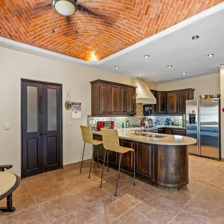 Kitchen with dark wood cabinets and stainless steel appliances in Rancho Los Labradores, San Miguel.