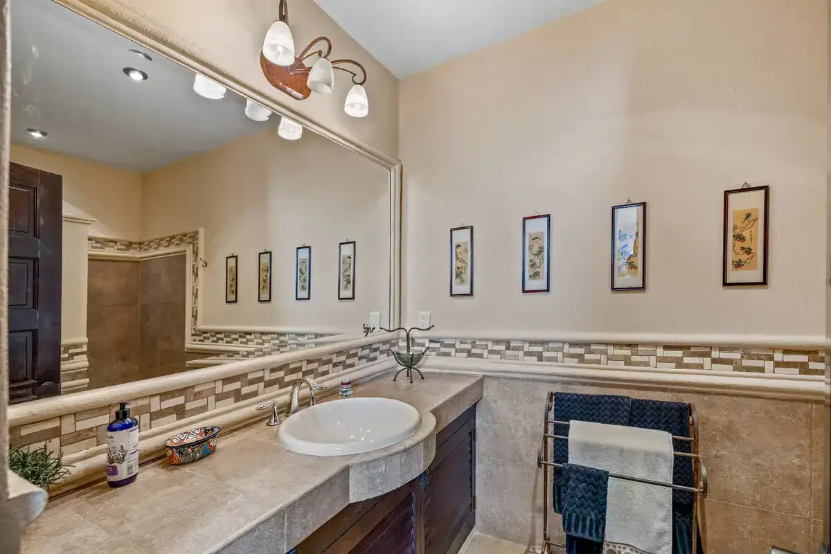 Elegant bathroom with modern fixtures and decorative wall art in a luxurious lakeside home. Luxurious bathroom featuring modern fixtures, decorative art, and elegant design in a lakeside prope.