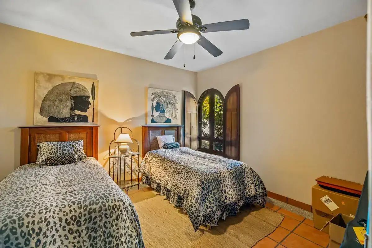 Lakefront Home for Sale in Rancho Los Labradores Beautiful bedroom with two beds, ceiling fan, and natural light in Rancho Los Labradores.
